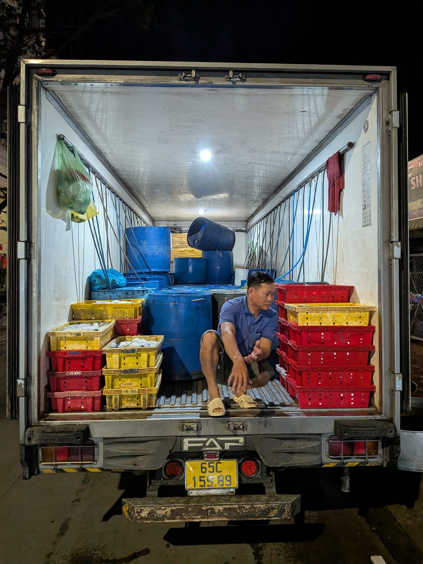 Crates and barrels of live fish loaded in a transport truck in Vietnam